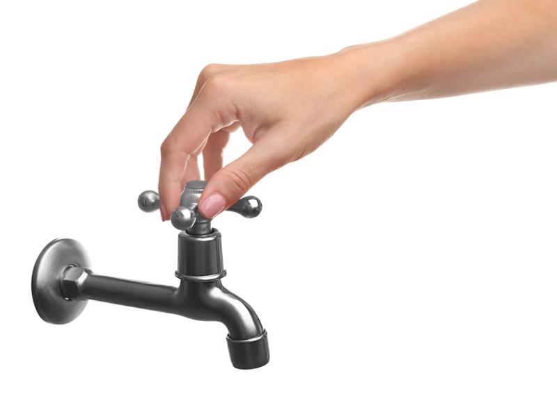 Hand turning on a faucet