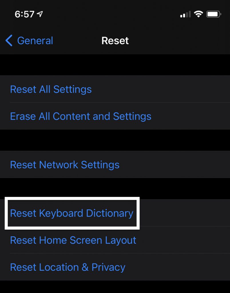 Screenshot of iPhone settings with arrow pointing to "Reset Keyboard Dictionary."