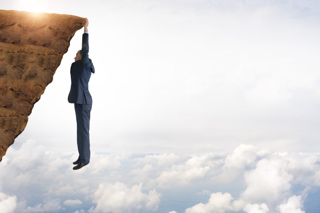 business concept challenge businessman clinging on