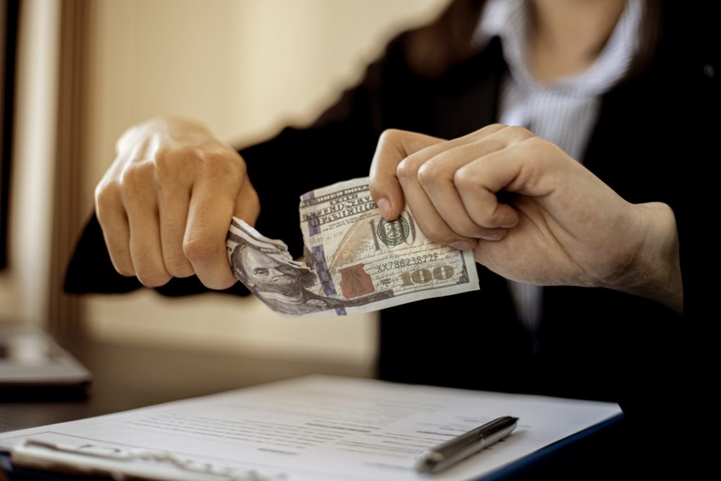 computer rip-off demonstrated by a person ripping a hundred dollar bill in half.