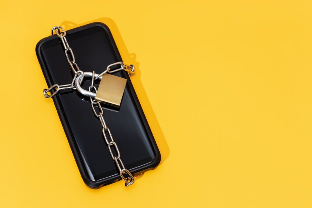 A smartphone with a chain and lock ited around it.